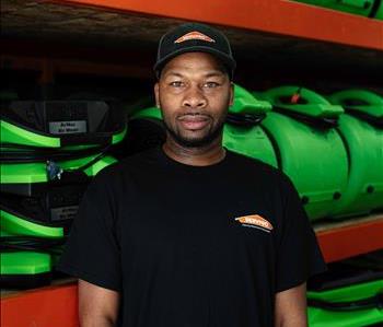 Male in front of servpro equipment with hat on